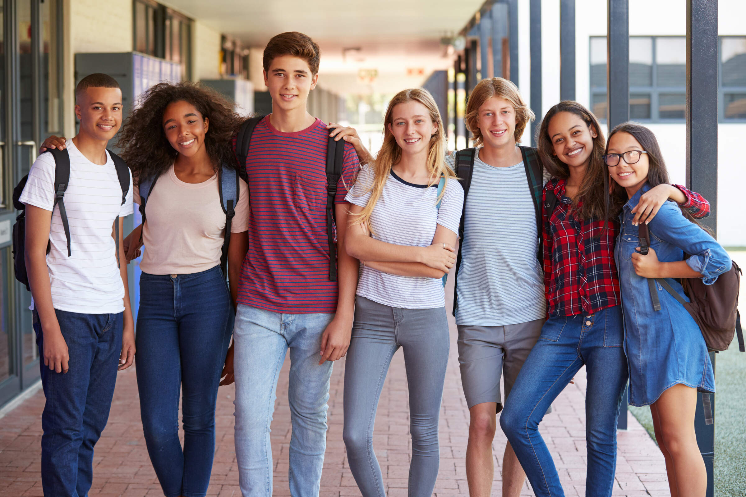 Teenage,Classmates,Standing,In,High,School,Hallway